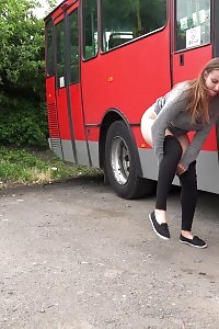 Big-breasted Brunette Taking A Leek Behind A Bus